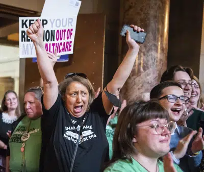 Opositores a una propuesta que prohibiría los abortos en Nebraska después de las seis semanas del embarazo, celebran en el Capitolio estatal, en Lincoln, Nebraska, luego de que el proyecto de ley no consiguió los votos necesarios para avanzar, el jueves 27 de abril de 2023. (Larry Robinson/Lincoln Journal Star vía AP)