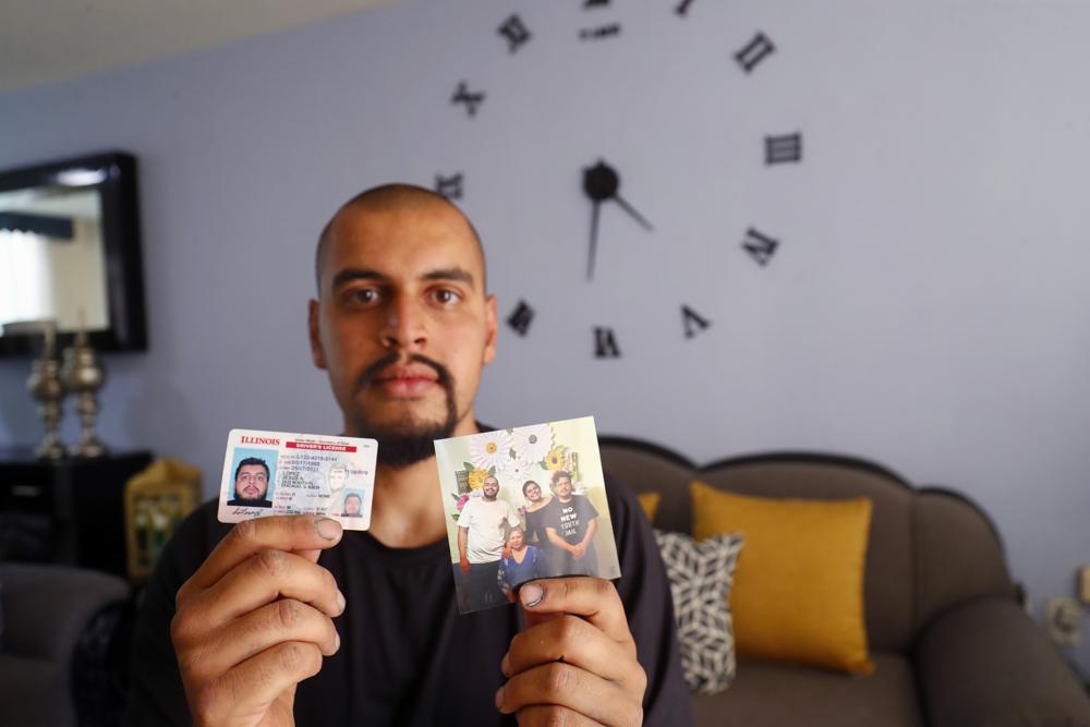 Jesús López, quien fue deportado por las autoridades de Estados Unidos el año pasado durante la pandemia del COVID-19, muestra su licencia de conducir de Illinois y una fotografía familiar en su casa en Zapopan, estado de Jalisco, el jueves 13 de mayo de 2021. “Allí (EEUU) es adonde pertenezco, donde tengo mis amigos, mi familia”, explicó el inmigrante de 25 años, que ahora vive en Guadalajara y que una vez recibió el programa de Acción Diferida para los Llegados en la Infancia o DACA (por sus siglas en inglés) que brinda protección a los inmigrantes traídos a los Estados Unidos cuando eran niños. (Foto AP/Refugio Ruiz)