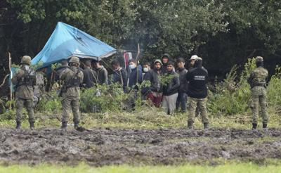 Guardias polacos impiden el paso de migrantes cerca de Usnarz Gorny, en la frontera con Bielorrusia, el 1ro de septiembre del 2021. Polonia dice que Bielorrusia envía migrantes en un esfuerzo por desestabilizar su gobierno y crearle problemas a la UE. (AP Photo/Czarek Sokolowski)
