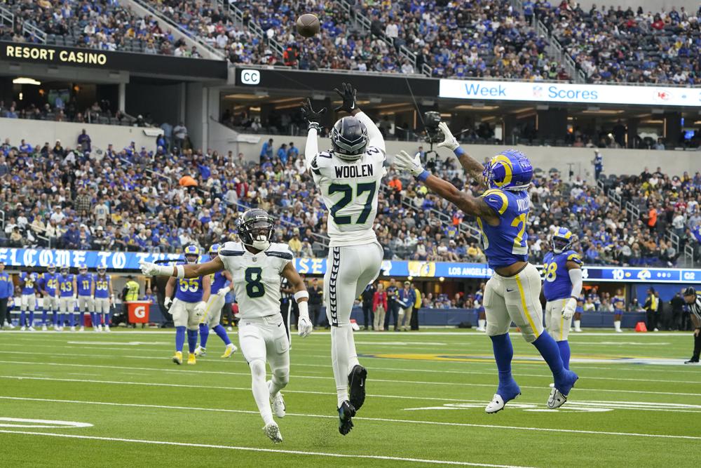Seattle Seahawks cornerback Tariq Woolen (27) intercepts a pass intended for Los Angeles Rams running back Kyren Williams, right, as Seahawks cornerback Coby Bryant (8) watches during the first half of an NFL football game Sunday, Dec. 4, 2022, in Inglewood, Calif. (AP Photo/Marcio Jose Sanchez)
