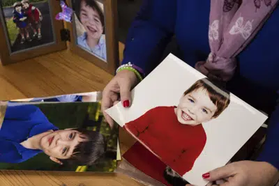 La cofundadora y directora ejecutiva de la Fundación Sandy Hook Promise, Nicole Hockley, muestra fotos de su hijo, Dylan, el 5 de diciembre de 2022, en su oficina en Newtown, Connecticut. Dylan fue uno de los 20 alumnos de primer grado y seis docentes asesinados en la escuela primaria Sandy Hook hace diez años. (AP Foto/Julia Nikhinson)