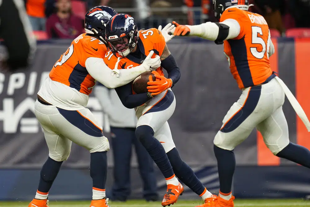 Denver Broncos safety Justin Simmons (31) celebrates his interception against the Arizona Cardinals with defensive tackle D.J. Jones (97) ) during the second half of an NFL football game, Sunday, Dec. 18, 2022, in Denver. (AP Photo/Jack Dempsey)