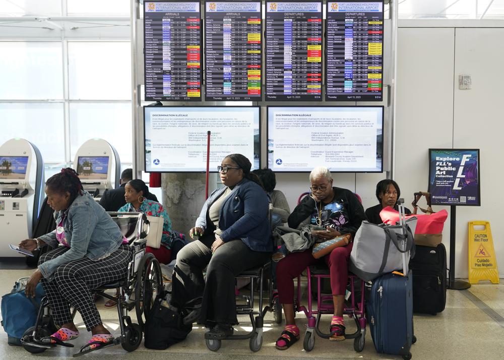 Passengers wait for flights to resume after Fort Lauderdale- Hollywood International Airport was closed due to flooding, Thursday, April 13, 2023, in Fort Lauderdale, Fla. Fort Lauderdale issued a state of emergency as flood conditions continued through many areas. Over 25 inches of rain fell in South Florida since Monday causing widespread flooding. (AP Photo/Marta Lavandier)