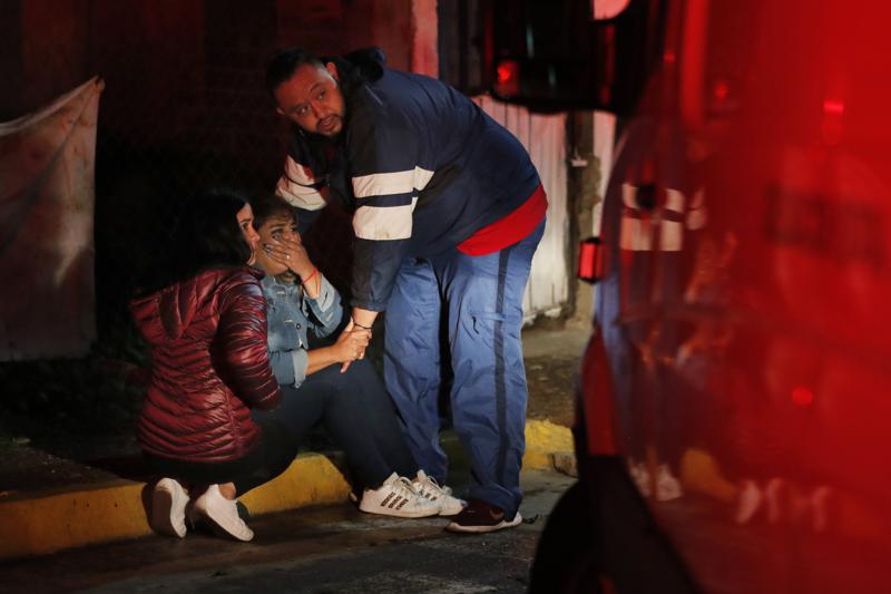 Relatives cry outside a house where two young men were gunned down in Fresnillo, Zacatecas state, Mexico,Tuesday, July 13, 2021. Fresnillo has the highest perception of insecurity in Mexico: more than 96% of its population lives in fear, according to the National Institute of Statistics and Geography. (AP Photo/Marco Ugarte)