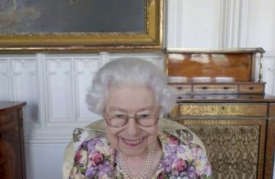 En esta imagen, tomada de un video, distribuida el 4 de junio de 2022 por el Palacio de Buckingham, se muestra a la reina Isabel II  de Inglaterra durante una videollamada con los galardonados al premio Australiano del Año, que se entregó antes de la celebración del Jubileo de Platino, en Londres. (Palacio de Buckingham vía AP)