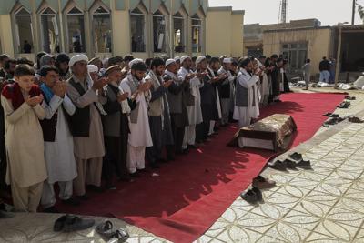Familiares y residentes rezan durante el entierro de las víctimas de un ataque suicida en la mezquita de Gozar-e-Sayed Abad, en Kunduz, en el norte de Afganistán, el 9 de octubre de 2021. (AP Foto/Abdullah Sahil)