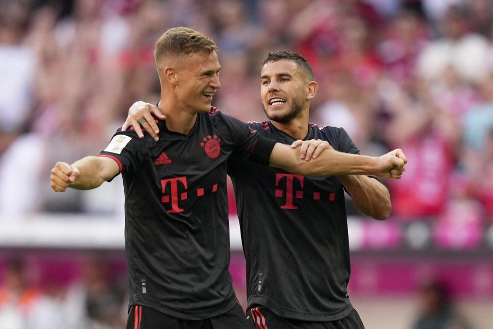 Joshua Kimmich y Lucas Hernández (derecha) celebran el segundo gol del Bayern Múnich ante Wolfsburgo en la Bundesliga, el domingo 14 de agosto de 2022. (AP Foto/Matthias Schrader)