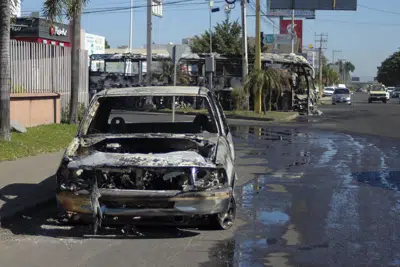 Los restos de un vehículo calcinado en la víspera, a un lado de una carretera en Culiacán, en el estado de Sinaloa, México, el 6 de enero de 2023. La operación del gobierno para detener a Ovidio Guzmán, el hijo del encarcelado capo del narcotráfico Joaquín "El Chapo" Guzmán, provocó enfrentamientos que mataron a 10 soldados y 19 supuestos miembros del cártel de Sinaloa, según las autoridades. (AP Foto/Martín Urista)