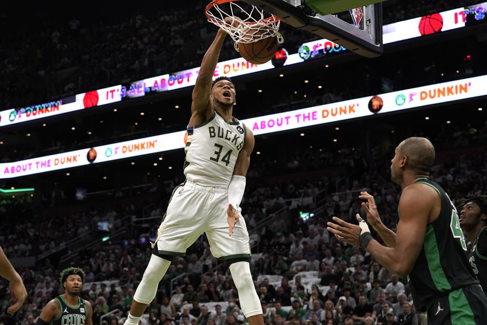 Milwaukee Bucks forward Giannis Antetokounmpo (34), of Greece, dunks as Boston Celtics guard Marcus Smart, left, and center Al Horford, right, look on in the first half of Game 1 in the second round of the NBA Eastern Conference playoff series, Sunday, May 1, 2022, in Boston. (AP Photo/Steven Senne)