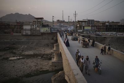 Afganos cruzan un puente sobre el río Kabul, en Kabul, Afganistán, el 28 de septiembre de 2021. (AP Foto/Felipe Dana)