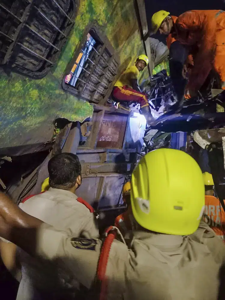 MANDATORY CREDIT- Rescuers work at the site of passenger trains that derailed in Balasore district, in the eastern Indian state of Orissa, Friday, June 2, 2023. Two passenger trains derailed in India, killing at least 13 people and trapping hundreds of others inside more than a dozen damaged coaches, officials said. About 400 people were injured and taken to hospitals, and the cause of the accident was under investigation, officials said. (Press Trust of India via AP)