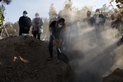 ARCHIVO - En esta imagen de archivo del 25 de junio de 2021, una familiar echa tierra sobre la tumba de Giro Quispe, fallecido por complicaciones asociadas al coronavirus, en el cementerio de El Cebollar, Arequipa, Perú. (AP Foto/Guadalupe Pardo, Archivo)