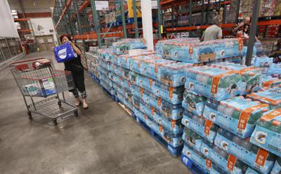Una compradora toma un paquete de botellas de agua el 26 de septiembre de 2022, en una tienda de la cadena Costco en Altamonte Springs, Florida. (Joe Burbank/Orlando Sentinel vía AP)