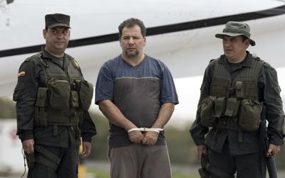 La policía escolta a Daniel Rendón-Herrera, alias "Don Mario," en el aeropuerto de Bogotá, Colombia, el 15 de abril del 2009. (AP Photo/William Fernando Martinez, File)