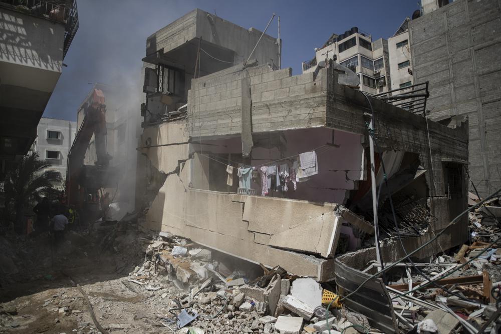 File - In this Sunday, May 16, 2021 file photo, Palestinian rescuers search for survivors under the rubble of one of al-Kawlak destroyed residential buildings following deadly Israeli airstrikes in Gaza City. The single deadliest bombing raid of Israel's fourth war with Hamas collapsed two apartment buildings and killed 22 members of the extended al-Kawlak family, including a 6-month-old boy and his 89-year-old great-grandfather (AP Photo/Khalil Hamra,File)