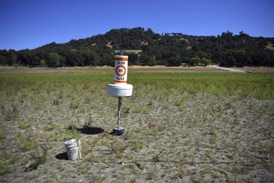 ARCHIVO - En esta fotografía de archivo del 23 de mayo de 2021, una boya permanece sobre tierra seca que estuvo cubierta de agua en el lago Mendocino, afectado por la sequía, en Ukiah, California. (AP Foto/Josh Edelson, archivo)