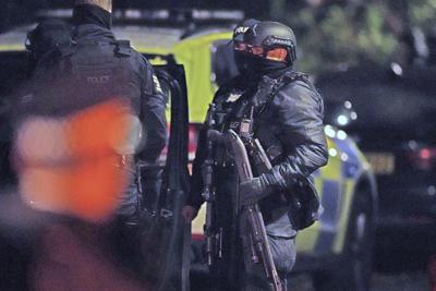 Un policía armado sostiene un arma para derribar puertas ante un inmueble de la Avenida Rutland, en Sefton park, tras una explosión en el Hospital de Mujeres de Liverpool, en Liverpool, Inglaterra, el lunes 15 de noviembre de 2021. (Peter Byrne/PA via AP)