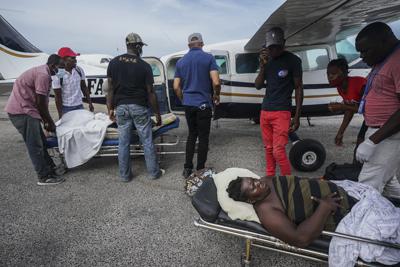 Residentes heridos por un terremoto de 7,2 grados de magnitud son llevados en camillas a una avioneta que los llevará a la capital del país, Puerto Príncipe, desde el aeropuerto en Les Cayes, Haití, el jueves 19 de agosto de 2021. (AP Foto/Fernando Llano)
