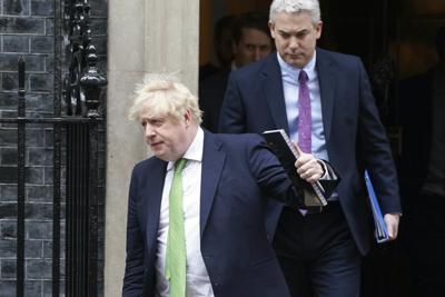 El primer ministro británico Boris Johnson seguido por su jefe de despacho Steve Barclay sale de la residencia de 10 Downing Street para dirigirse al Parlamento. (Joe Cook/PA via AP)