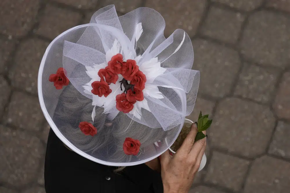 A race fan walks on the grounds of Churchill Downs before the 149th running of the Kentucky Derby horse race Saturday, May 6, 2023, in Louisville, Ky. (AP Photo/Charlie Riedel)