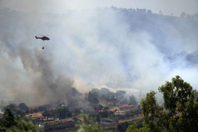 Un helicóptero vuela sobre el poblado de Markati, a unos 60 kilómetros (37 millas) al sur de Atenas, Grecia, el lunes 16 de agosto de 2021. (AP Foto/Thanassis Stavrakis)