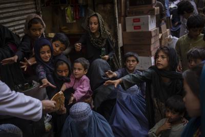 Mujeres y niños afganos reciben donaciones de pan en la Ciudad Vieja de Kabul, Afganistán, el 16 de septiembre de 2021. (AP Foto/Bernat Armangué)