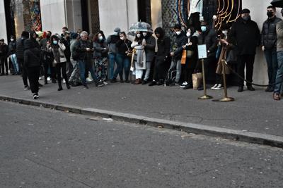 Personas esperan afuera de una tienda en la avenida Champs Elysees en París, el martes 28 de diciembre de 2021. (AP Foto/Thibault Camus)