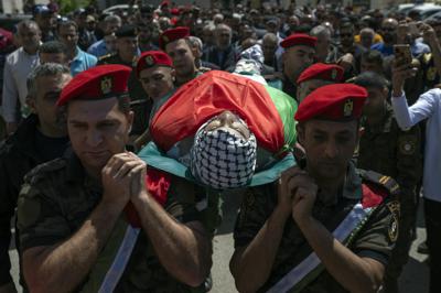Agentes de seguridad palestinos trasladan el cuerpo de Muhammad Assaf durante su entierro en al aldea cisjordana de Kufr Laqef, cerca de Qalqiliya, el 13 de abril de 2022. (AP Foto/Nasser Nasser)