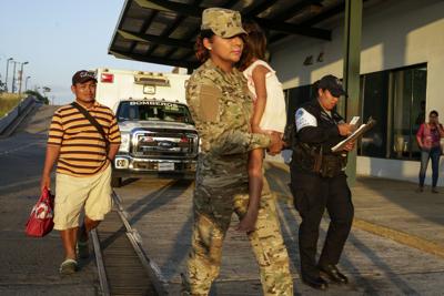 ARCHIVO - José González, a la izquierda, sigue a su hija de 5 años, cargada por un oficial de policía, cuando salen de un hospital en Santiago, Panamá, el jueves 16 de enero de 2020. La esposa de González y cinco de sus hijos se encuentran entre siete personas asesinadas en un ritual religioso en la comunidad indígena Ngabe Bugle. (AP Foto/Arnulfo Franco, Archivo)