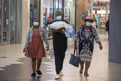 Gente recorre un centro comercial en Johannesburgo, Sudáfrica, viernes 26 de noviembre de 2021. Asesores de la Organización Mundial de la Salud se reúnen para estudiar la información sobre una nueva variante del coronavirus que ha aparecido en Sudáfrica. Su impacto sobre las vacunas contra el COVID-19 posiblemente no se conocerá hasta dentro de varias semanas. (AP Foto/Denis Farrell)