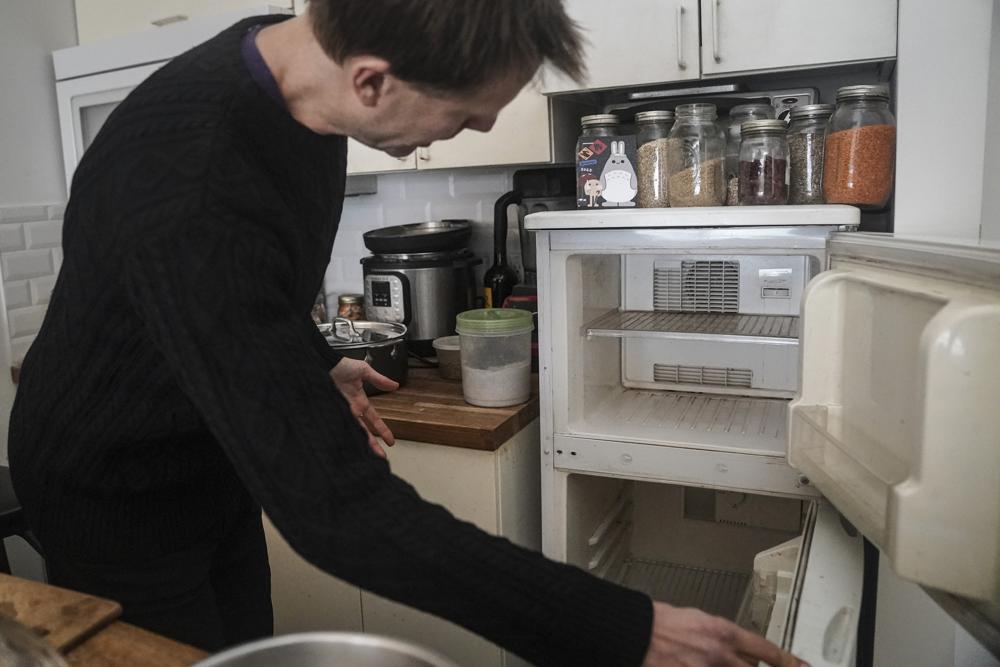 Josh Spodek shows the empty refrigerator in his Greenwich Village apartment he ditched to support his effort to live sustainably, Tuesday Jan. 24, 2023, in New York. Beyond the energy savings, Spodek says without a refrigerator he has learned to cook better and develop fermentation techniques using a wider variety of seasonal produce. (AP Photo/Bebeto Matthews)