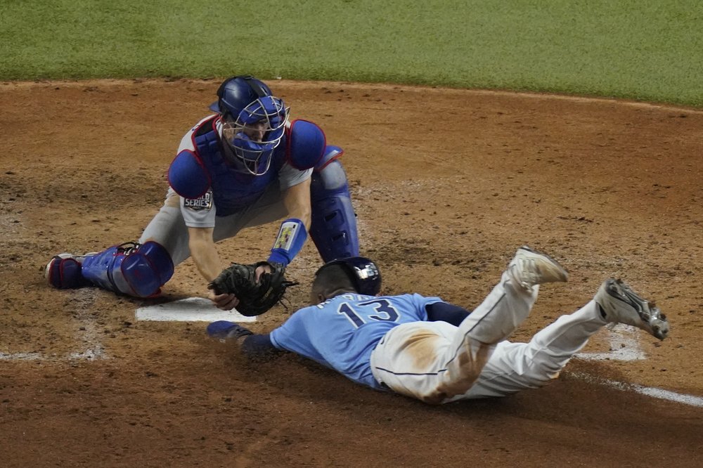 Manuel Margot, de los Rays de Tampa Bay Rays, es puesto fuera en home por el receptor de los Dodgers de Los Ángeles Austin Barnes tratando de robar durante la cuarta entrada en el Juego 5 de la Serie Mundial de la MLB el domingo 25 de octubre de 2020.