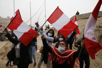 Los partidarios de la candidata presidencial Keiko Fujimori ondean banderas peruanas esperando su llegada a un desayuno en el barrio de San Juan de Lurigancho en Lima, Perú, el domingo 6 de junio de 2021. (Foto AP/Guadalupe Prado)