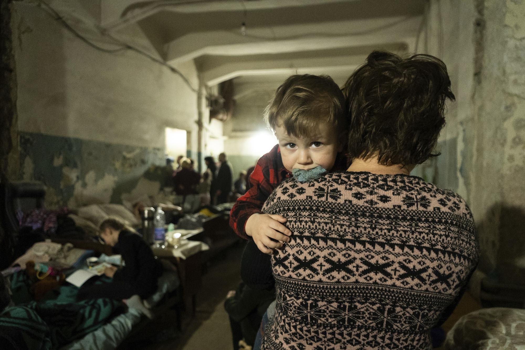 A woman holds a child in an improvised bomb shelter in Mariupol, Ukraine, Monday, March 7, 2022. (AP Photo/Mstyslav Chernov)