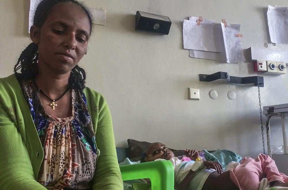 In this image made from video provided anonymously, Mizan Wolde sits with her daughter Genet Mehari, 5, in the malnutrition ward at the Ayder Referral Hospital in Mekele, in the Tigray region of northern Ethiopia, Tuesday, Sept. 28, 2021. In the regional capital Mekele, a year of war and months of government-enforced deprivation have left the city of a half-million people with a rapidly shrinking stock of food, fuel, medicine and cash. (AP Photo)