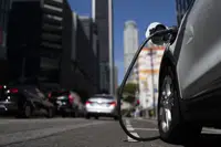 FILE - An electric vehicle is plugged into a charger in Los Angeles, Thursday, Aug. 25, 2022. Fewer new electric vehicles will qualify for a full $7,500 federal tax credit later this year, and many will get only half that under rules proposed Friday, March 30, 2023, by the U.S. Treasury Department. The rules are required under last year’s Inflation Reduction Act. (AP Photo/Jae C. Hong, File)