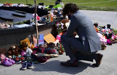 El primer ministro de Canadá Justin Trudeau visita un memorial junto a la Llama Eterna junto al Parlamento en Ottawa el 1 de junio del 2021, que fue colocado en reconocimiento del descubrimiento de los restos de niños indígenas en el sitio de una antigua escuela residencial en Kamloops, Columbia Británica.  (Sean Kilpatrick/The Canadian Press vía AP)