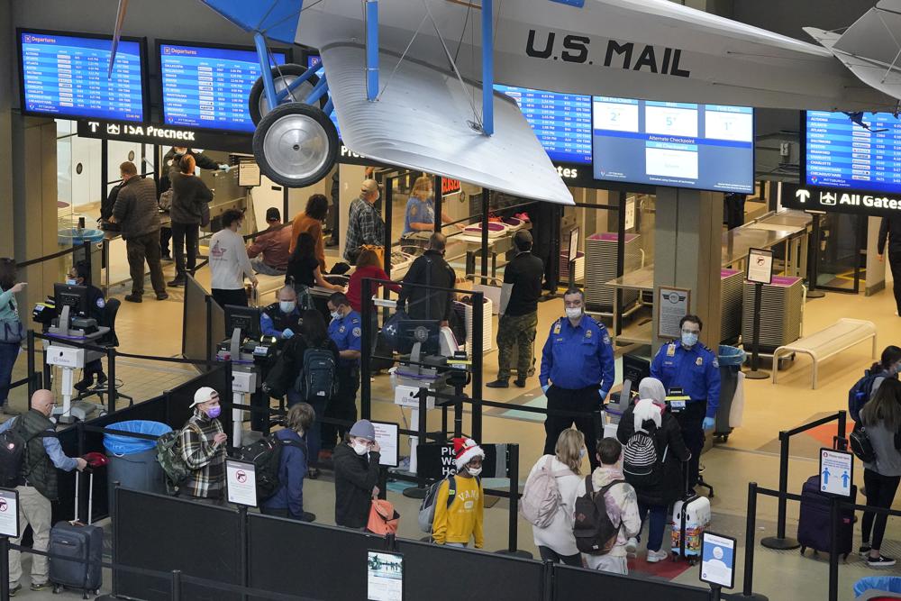 Los viajeros de vacaciones hacen fila en el punto de control de seguridad en el aeropuerto internacional de Pittsburgh en Imperial, Pensilvania, el jueves 23 de diciembre de 2021. Al menos tres aerolíneas importantes dicen que han cancelado docenas de vuelos el viernes 24 de diciembre debido a enfermedades en gran parte. vinculados a la variante omicron de COVID-19 han afectado el número de tripulantes de vuelo durante la ajetreada temporada de viajes de vacaciones.  (Foto AP / Gene J. Puskar)