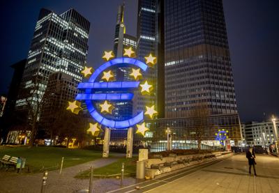 ARCHIVO - Un hombre camina ceca de la escultura del Euro en Fráncfort, Alemania, el 11 de marzo de 2021. (AP Foto/Michael Probst, archivo)