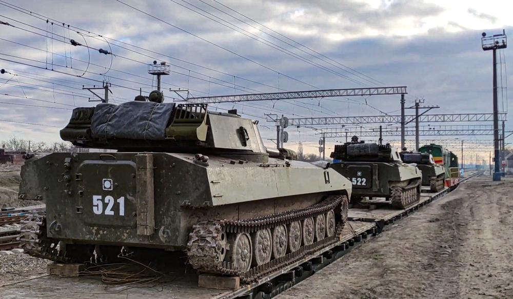 In this photo taken from video provided by the Russian Defense Ministry Press Service on Tuesday, Feb. 15, 2022, Russian armored vehicles are loaded onto railway platforms after the end of military drills in South Russia. In what could be another sign that the Kremlin would like to lower the temperature, Russia's Defense Ministry announced Tuesday that some units participating in military exercises would begin returning to their bases. (Russian Defense Ministry Press Service via AP)