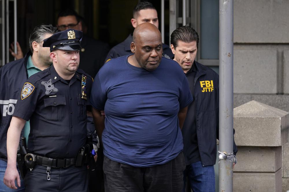 New York City Police and law enforcement officials lead subway shooting suspect Frank R. James, 62, center, away from a police station, in New York, Wednesday, April 13, 2022. The man accused of shooting multiple people on a Brooklyn subway train was arrested Wednesday and charged with a federal terrorism offense. (AP Photo/Seth Wenig)