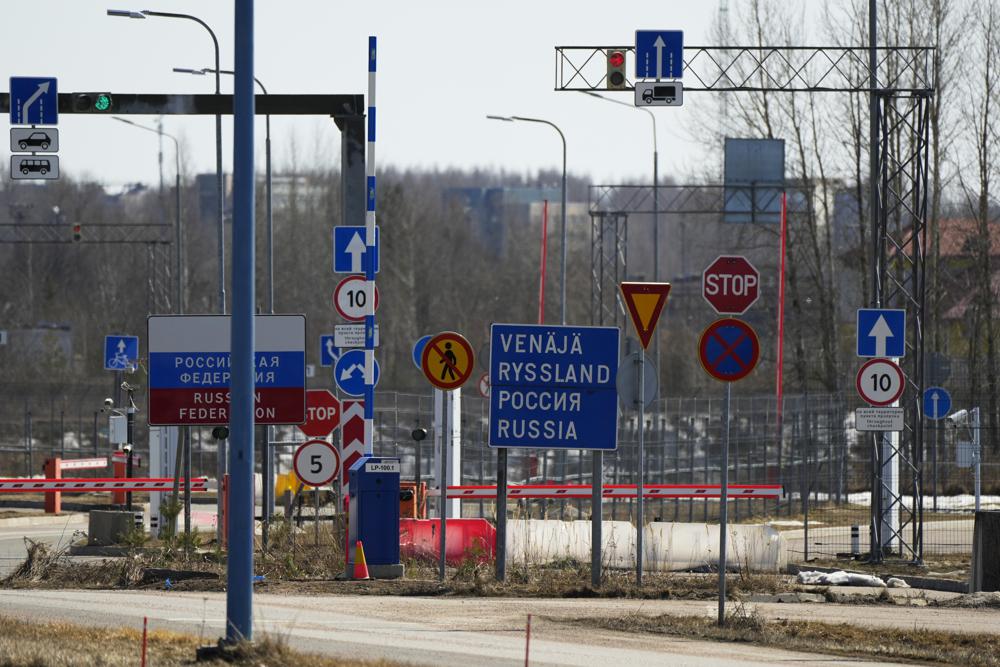 Road signs "Russian Federation", left, and "Russia" are seen at the Russian border crossing point Svetogorsk from Pelkola border crossing point in Imatra, south-eastern Finland, Friday, April 14, 2023. (AP Photo/Sergei Grits)