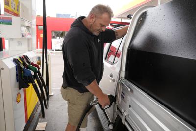 Ivan Pintur pumps fuel into his truck at a service station in Sydney, Tuesday, March 29, 2022. With inflation increasing in Australia and many parts of the world driven in part by higher oil prices, the government is expected to reduce its 44.2 Australian cents (33.1 U.S. cents) a liter ($1.25 a gallon) tax on gasoline. (AP Photo/Rick Rycroft)