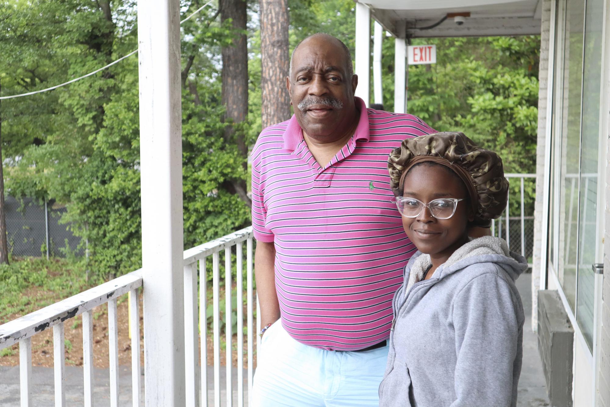 Dana Williams and his daughter De'mai Williams stand outside a low-cost hotel in Atlanta on May 18, 2023. The two have been looking for an affordable place to live ever since they were evicted from their two-bedroom apartment in April. (AP Photo/R.J. Rico)