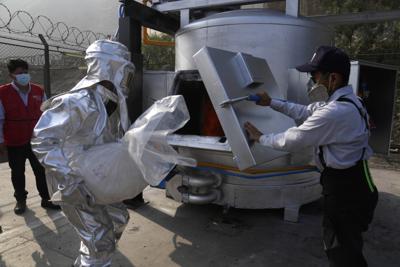 Un oficial de policía coloca una bolsa de cocaína incautada en un incinerador en una base policial en Lima, Perú, el lunes 18 de abril de 2022.  (AP Foto/Martín Mejía)