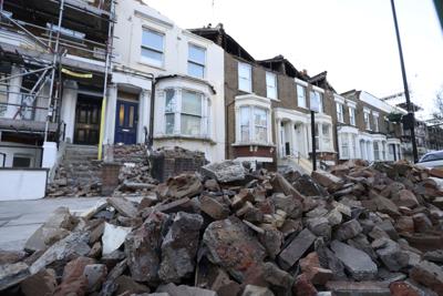 Escombros de los tejados de tres casas afectadas por el paso de la tormenta Eunice, sobre la calzada en Kilburn Park Road, en el noroeste de Londres, el 18 de febrero de 2022. (James Manning/PA vía AP)