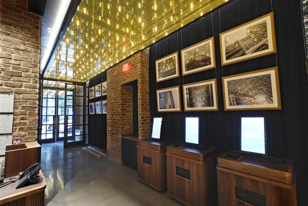 The entrance and lobby of the new Civilian hotel appears in New York's Theater District, Monday, Nov. 15, 2021. The 203-room hotel is packed with hundreds of pieces of Broadway art, including sketches, set models, costume pieces, photographs and artifacts that show theater past and present.  (AP Photo/Richard Drew)