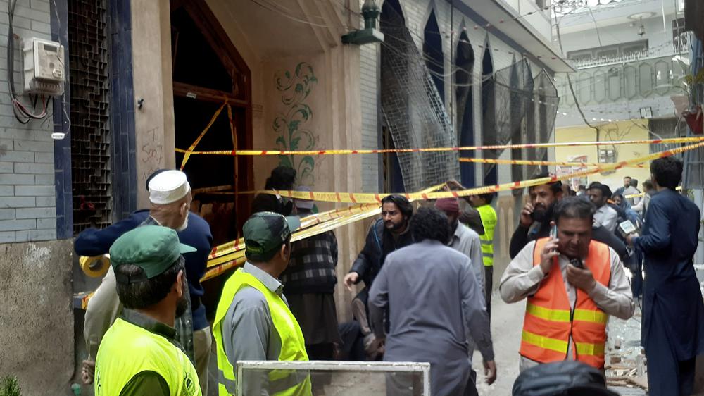 Rescue workers and volunteers gather at the site of bomb explosion in Peshawar, Pakistan, Friday, March 4, 2022. A powerful bomb exploded inside a Shiite Muslim mosque in Pakistan's northwestern city of Peshawar on Friday, killing more than 30 worshippers and wounding dozens more, many of them critically, police said. (AP Photo/Muhammad Sajjad)