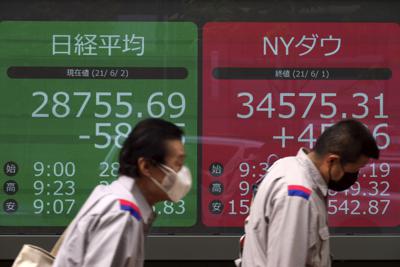 Personas frente a una cartelera financiera en Tokio el 2 de junio del 2021.   (Foto AP/Eugene Hoshiko)