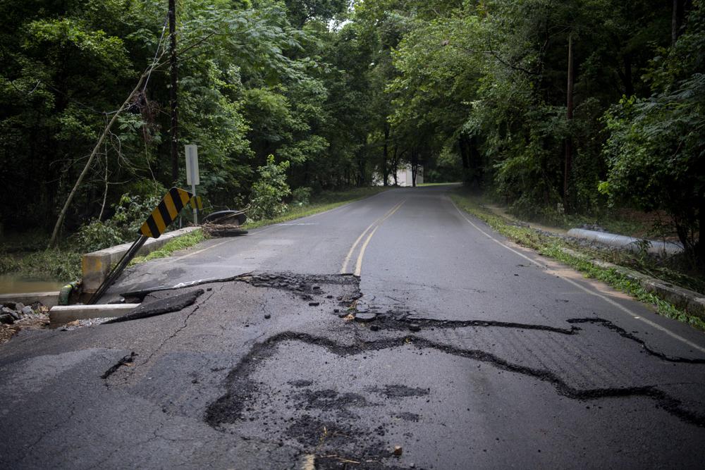 Layers of pavement are ripped up from Harris Road following heavy rainfall and flooding on Saturday, Aug. 21, 2021, in Dickson, Tenn. (Josie Norris/The Tennessean via AP)
